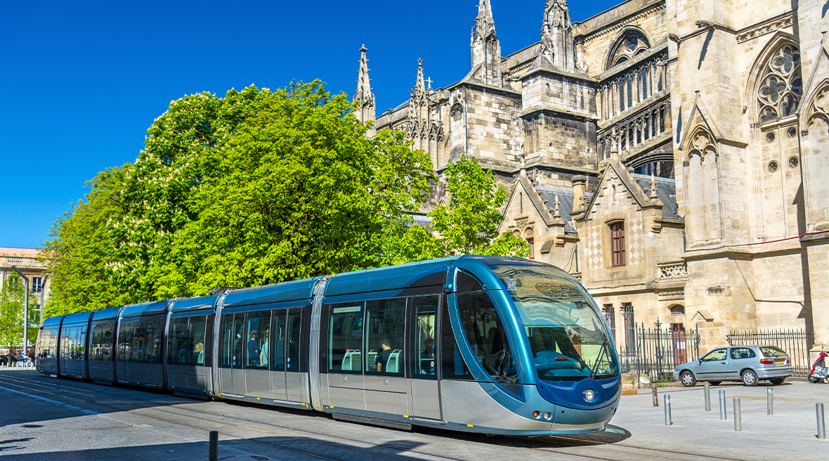 Tram pulling up outside beautiful French architecture in Bordeaux city centre